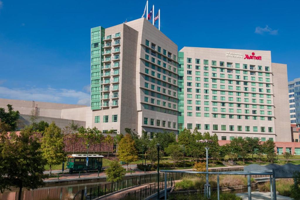 Fachada iluminada de un hotel Marriott frente al canal al anochecer