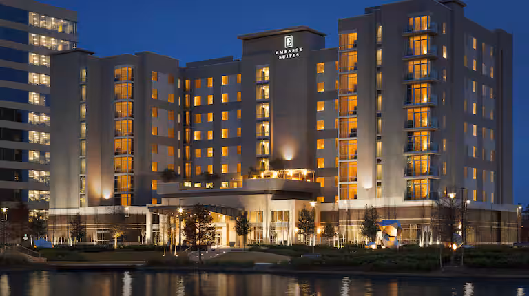 Atrio moderno de un hotel Embassy Suites con iluminación cálida
